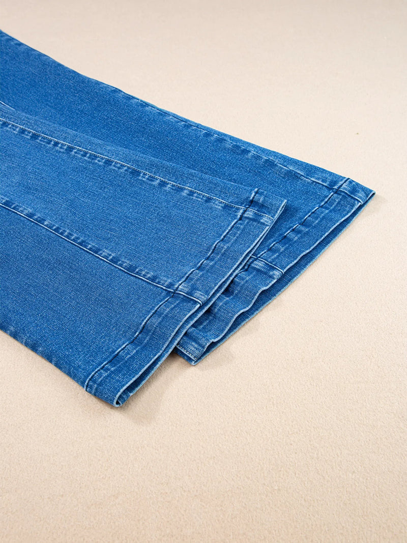Blue denim jeans folded on a beige surface