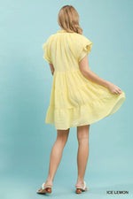 Woman wearing a yellow dress against a light blue background