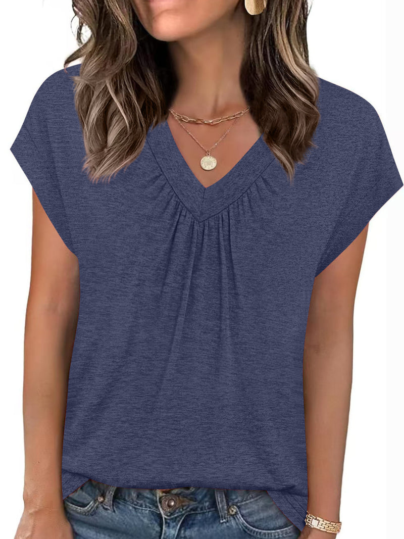 Woman wearing a blue short-sleeve top with a plain background