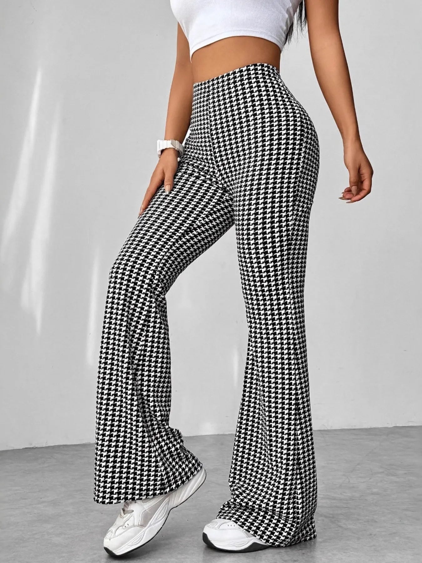 Person wearing houndstooth patterned pants on a plain background