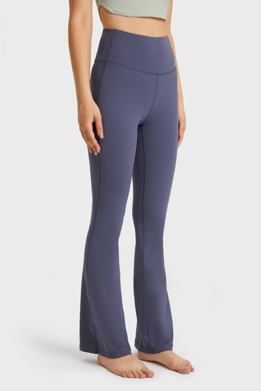 Person wearing purple flared pants on a white background