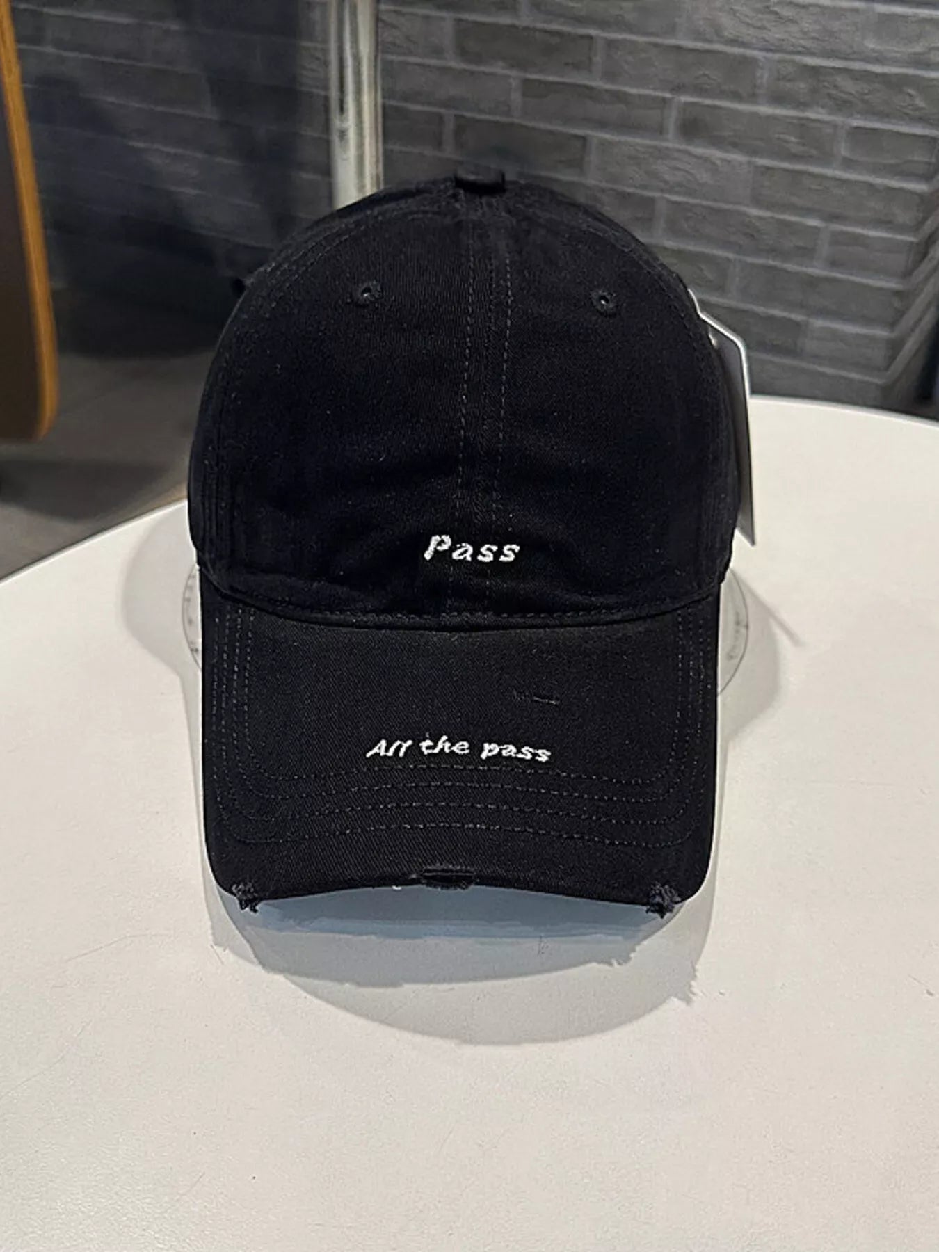 Black cap with text on a white surface and gray background
