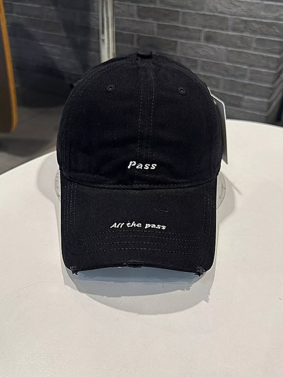 Black cap with text on a white surface and gray background