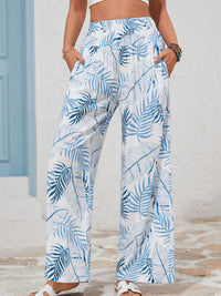 Person wearing blue and white leaf-patterned pants with a neutral background