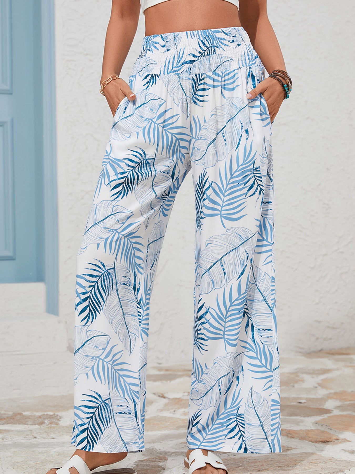 Person wearing blue and white leaf-patterned pants with a neutral background