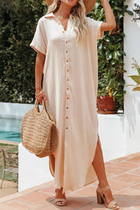 Woman in a beige dress holding a straw bag outdoors near a pool.