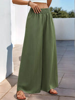 Person wearing green wide-leg pants on a sunny day.