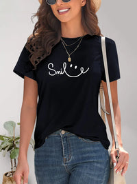 Woman wearing a black t-shirt with 'Smile' text and smiling.
