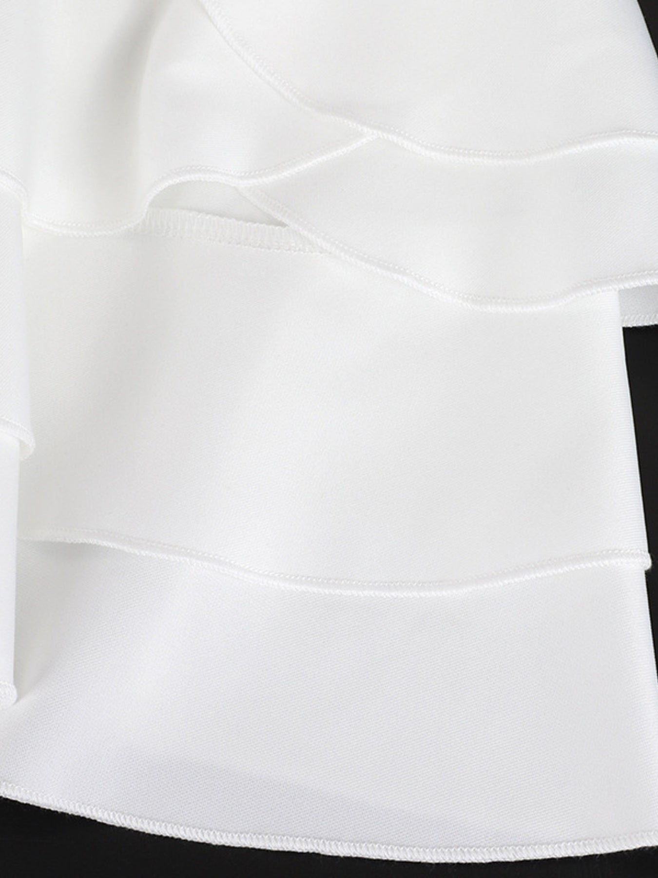 Close-up of a white skirt with a black waistband