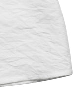 Close-up of a textured white fabric corner on a white background