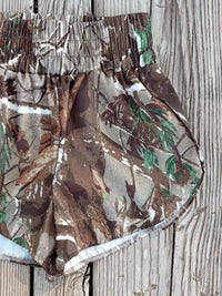 Camouflage swim shorts on a wooden surface