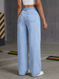 Person wearing light blue jeans in an industrial setting