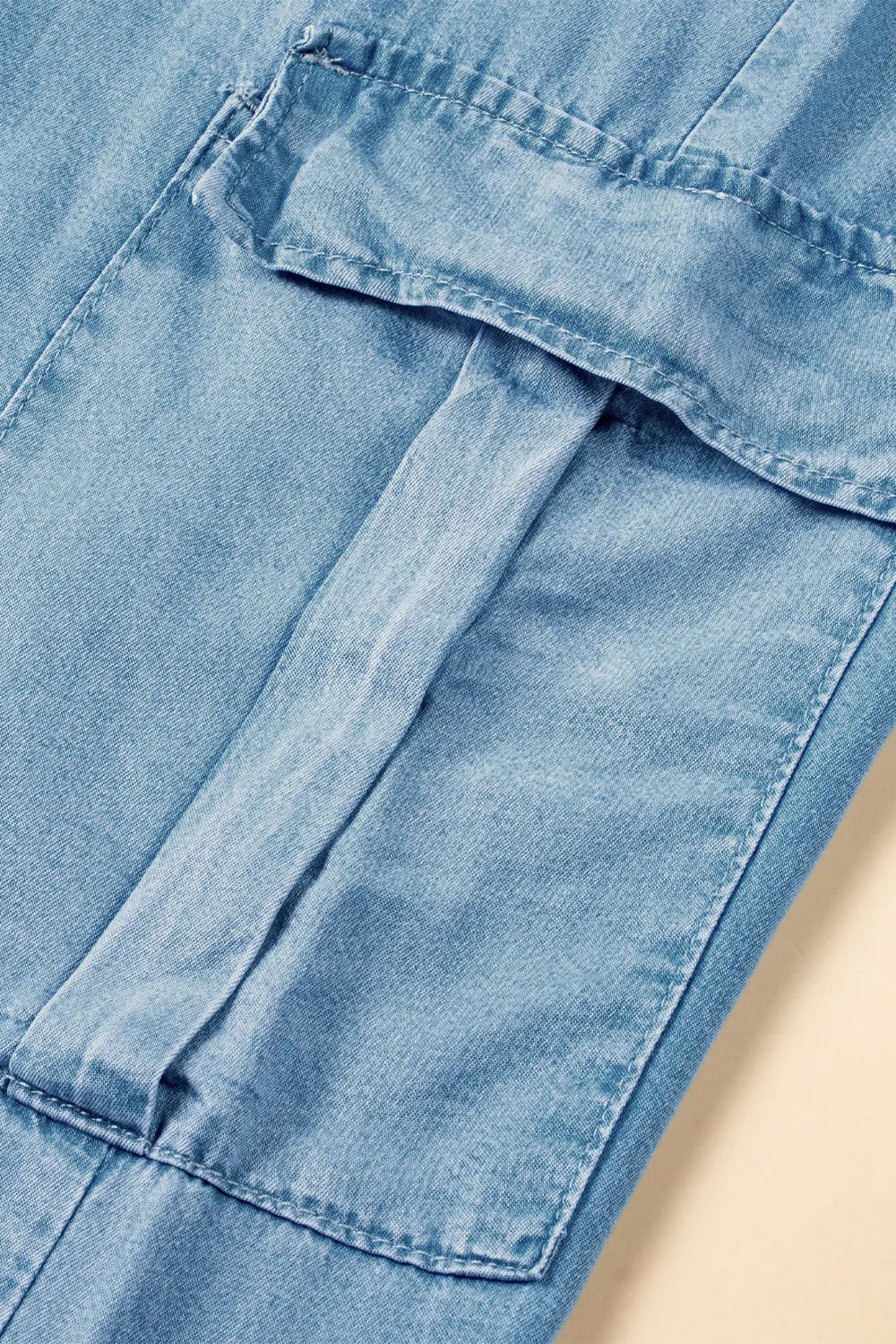 Close-up of blue denim fabric with a beige background