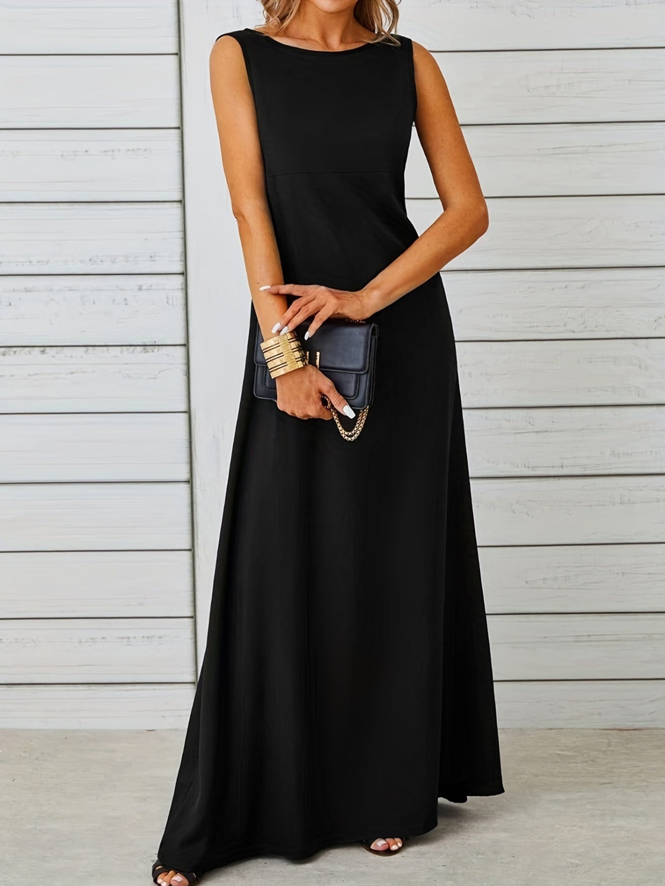 Woman wearing a black sleeveless dress against a light wooden panel background