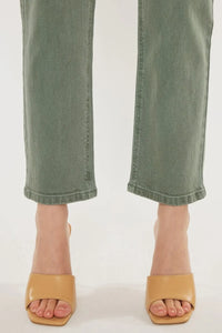 Green jeans and tan sandals on a white background