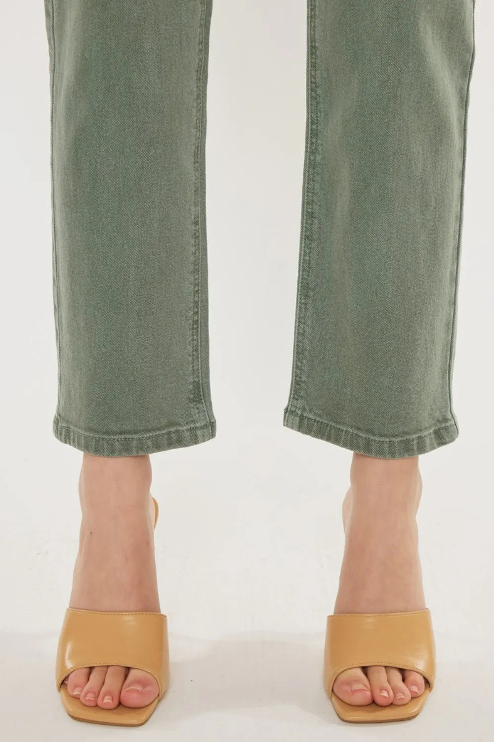 Green jeans and tan sandals on a white background