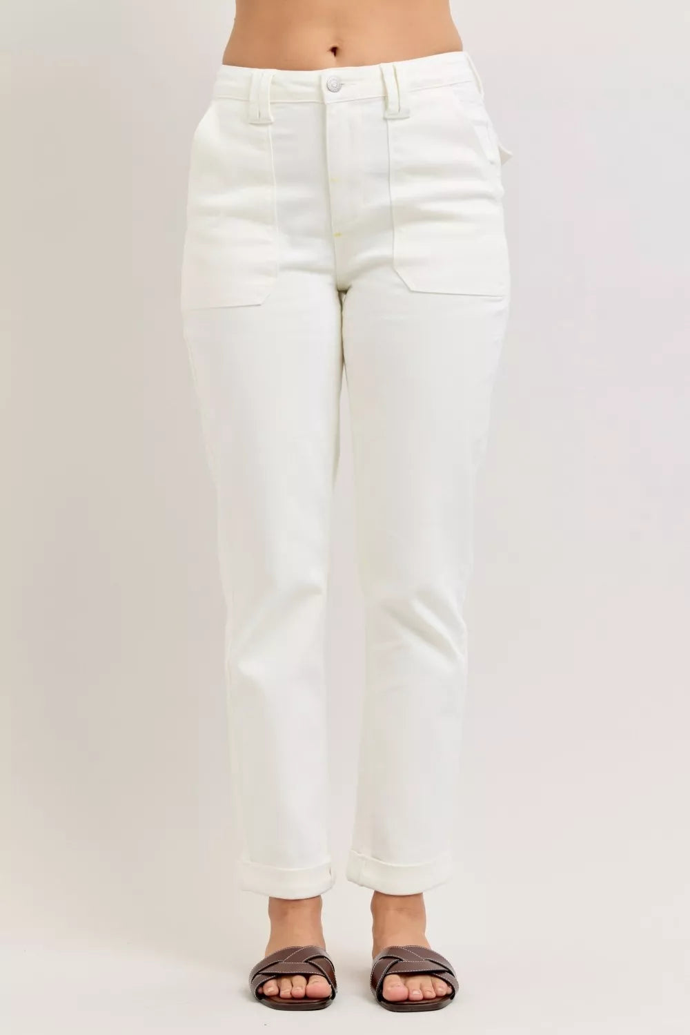 White jeans worn by a person on a plain background