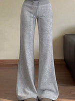 Light gray wide-leg sweatpants with a drawstring waist, shown on a model standing indoors on a wooden floor.