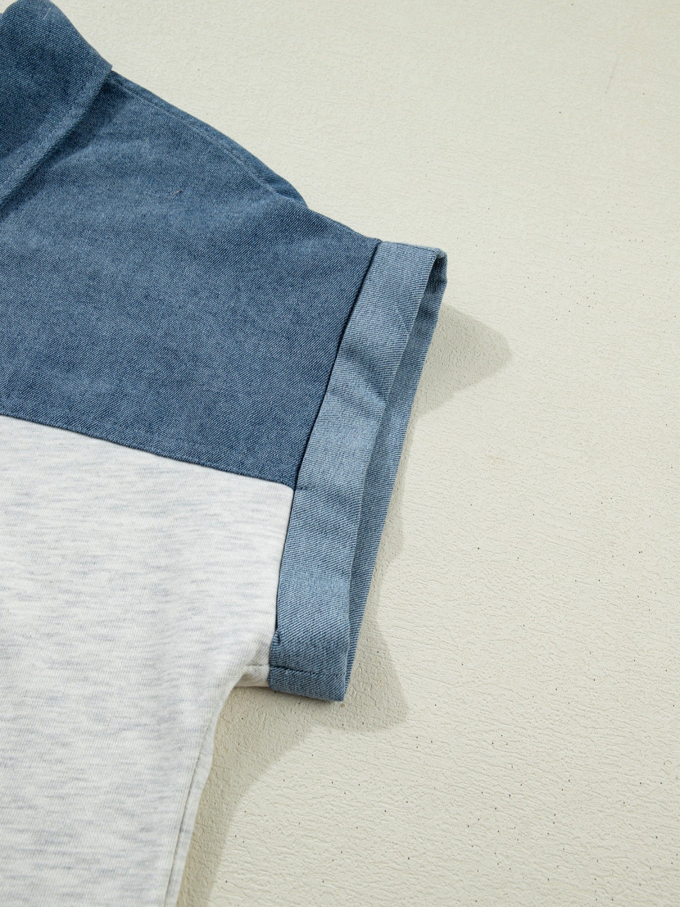 Close-up of a blue and gray fabric edge on a beige background