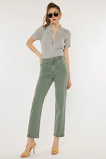 Woman wearing a gray top and green pants on a white background