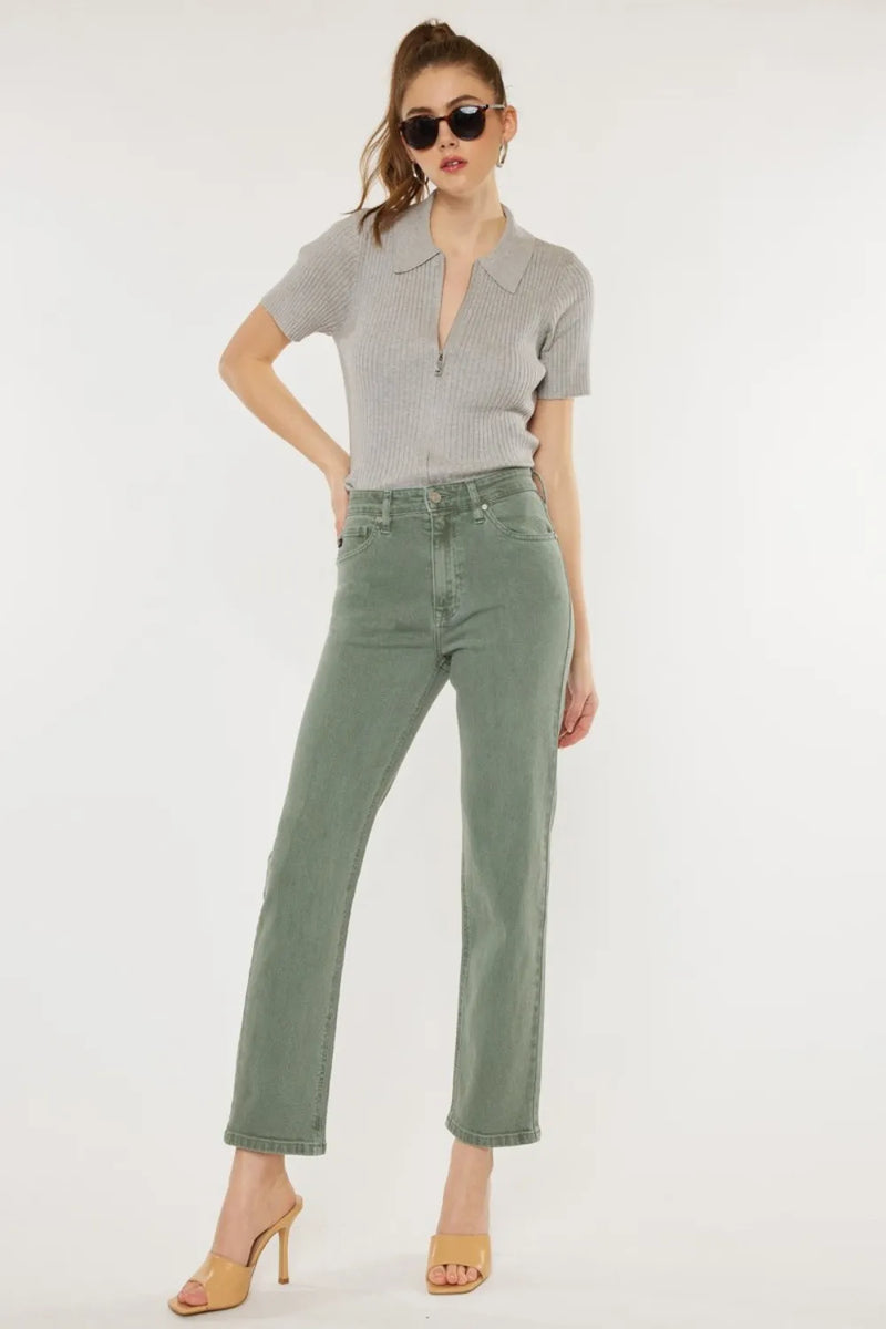 Woman wearing a gray top and green pants on a white background