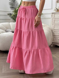 Person wearing a pink tiered skirt in a room with a couch and dresser.