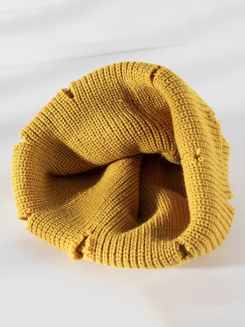 Yellow knitted beanie on a white background