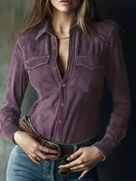Person wearing a purple button-up shirt and blue jeans against a dark background