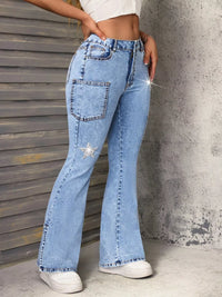 Person wearing light blue flared jeans with a star embellishment against a textured wall.