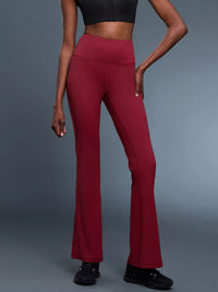 Person wearing red flared pants on a gray background