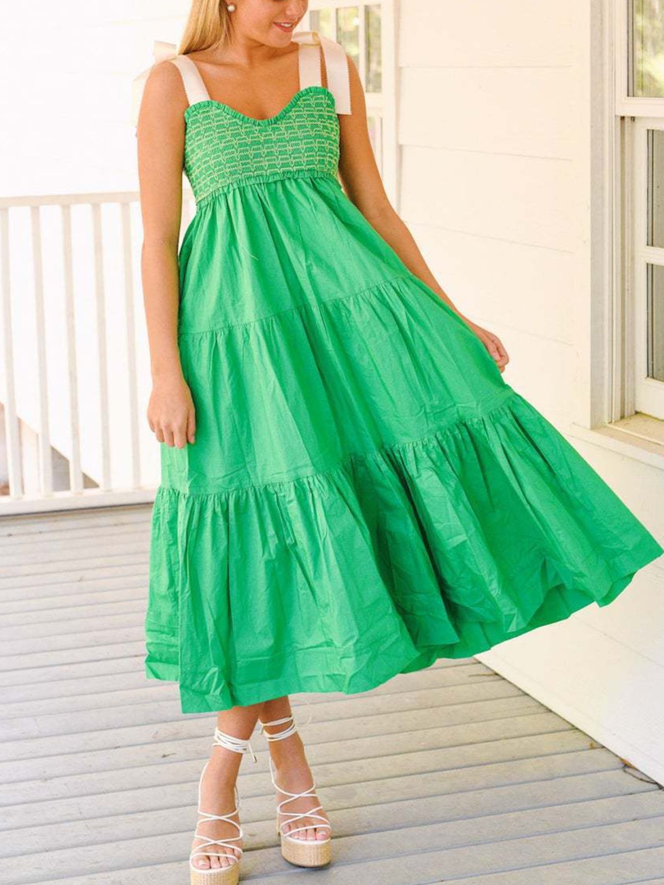 Woman wearing a green dress on a wooden deck