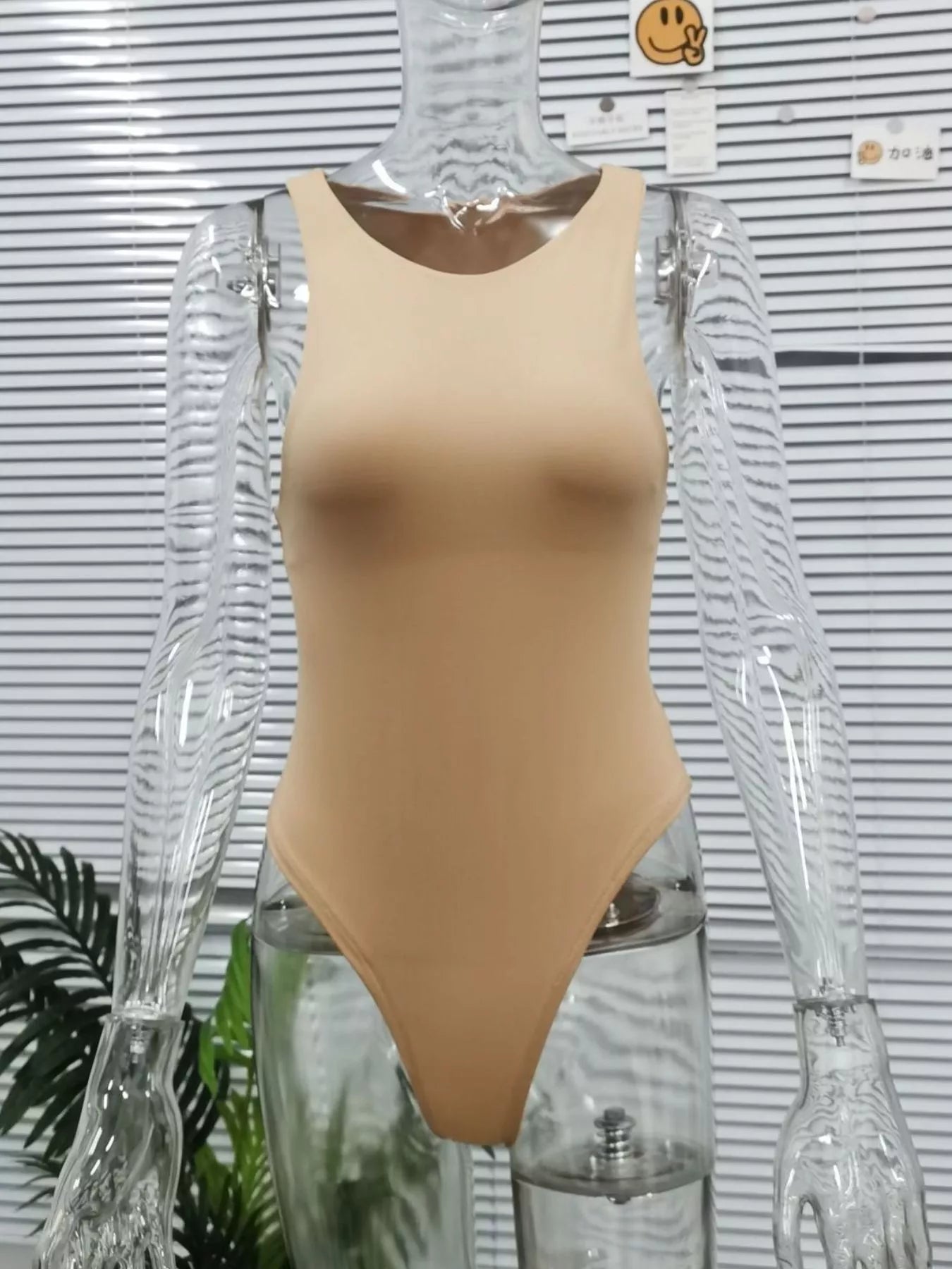 Beige swimsuit on a mannequin against a striped background