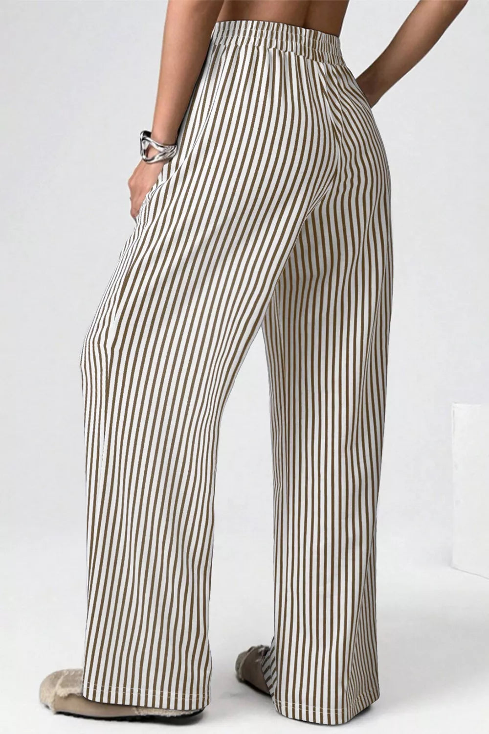 Striped pants worn by a person on a white background