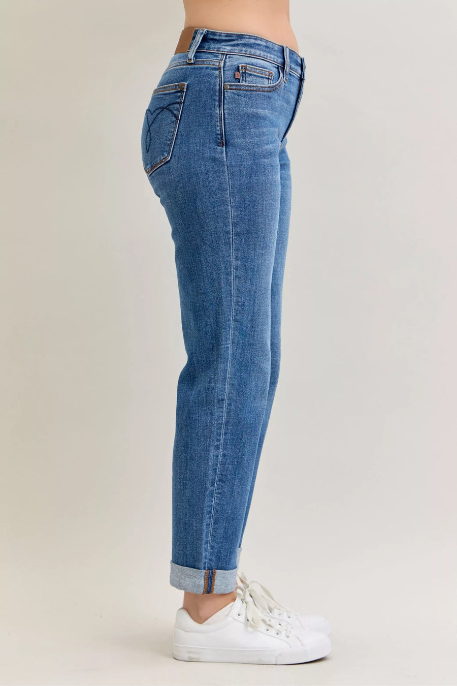 Blue jeans worn by a person on a plain background