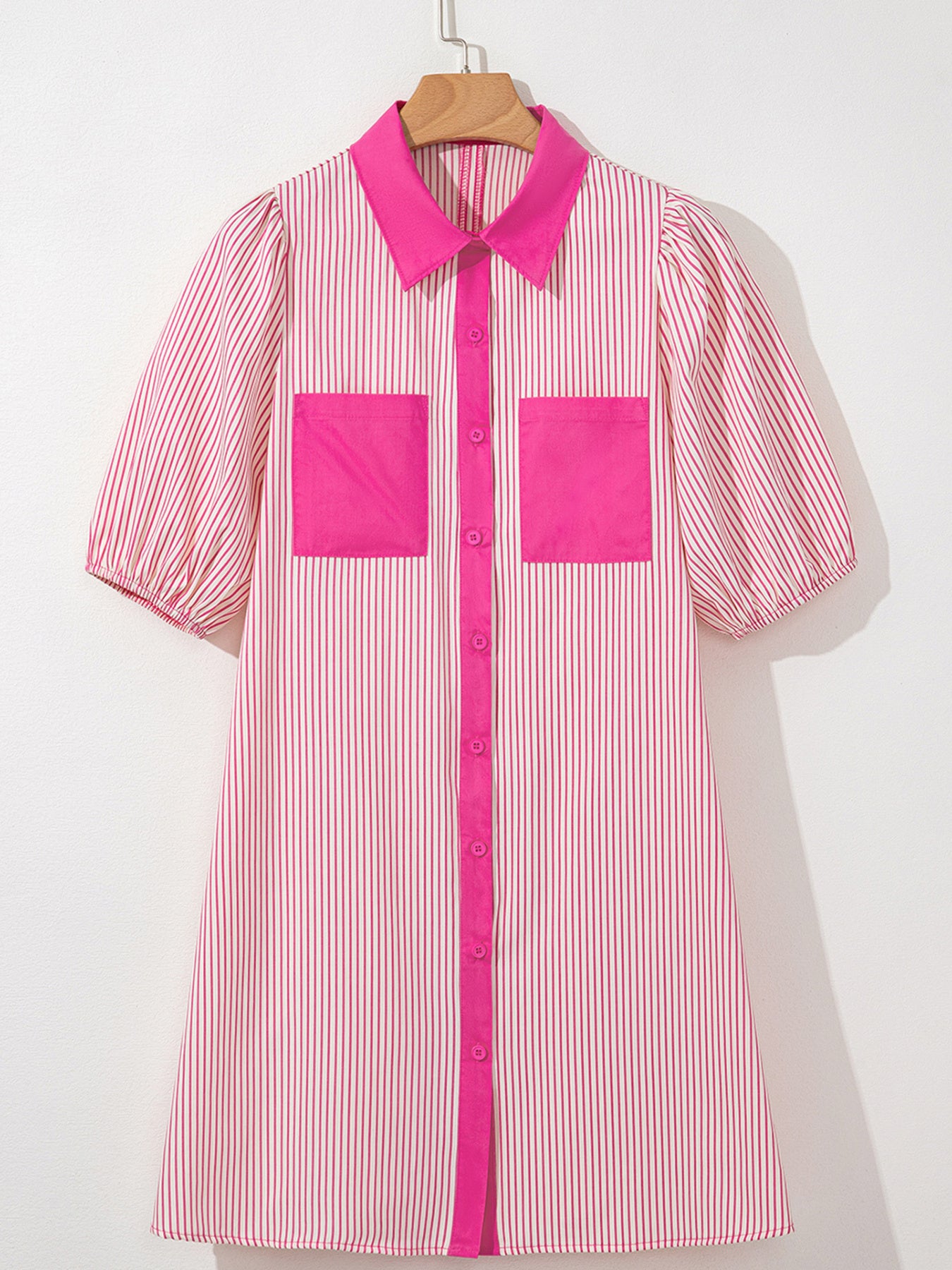 Pink and white striped shirt with pink accents on a hanger against a white background