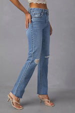 Blue jeans worn by a person on a gray background