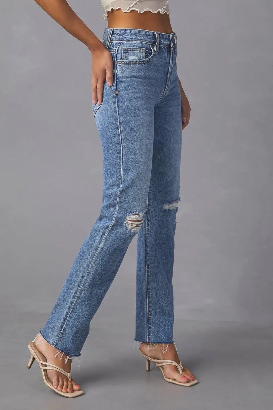 Blue jeans worn by a person on a gray background