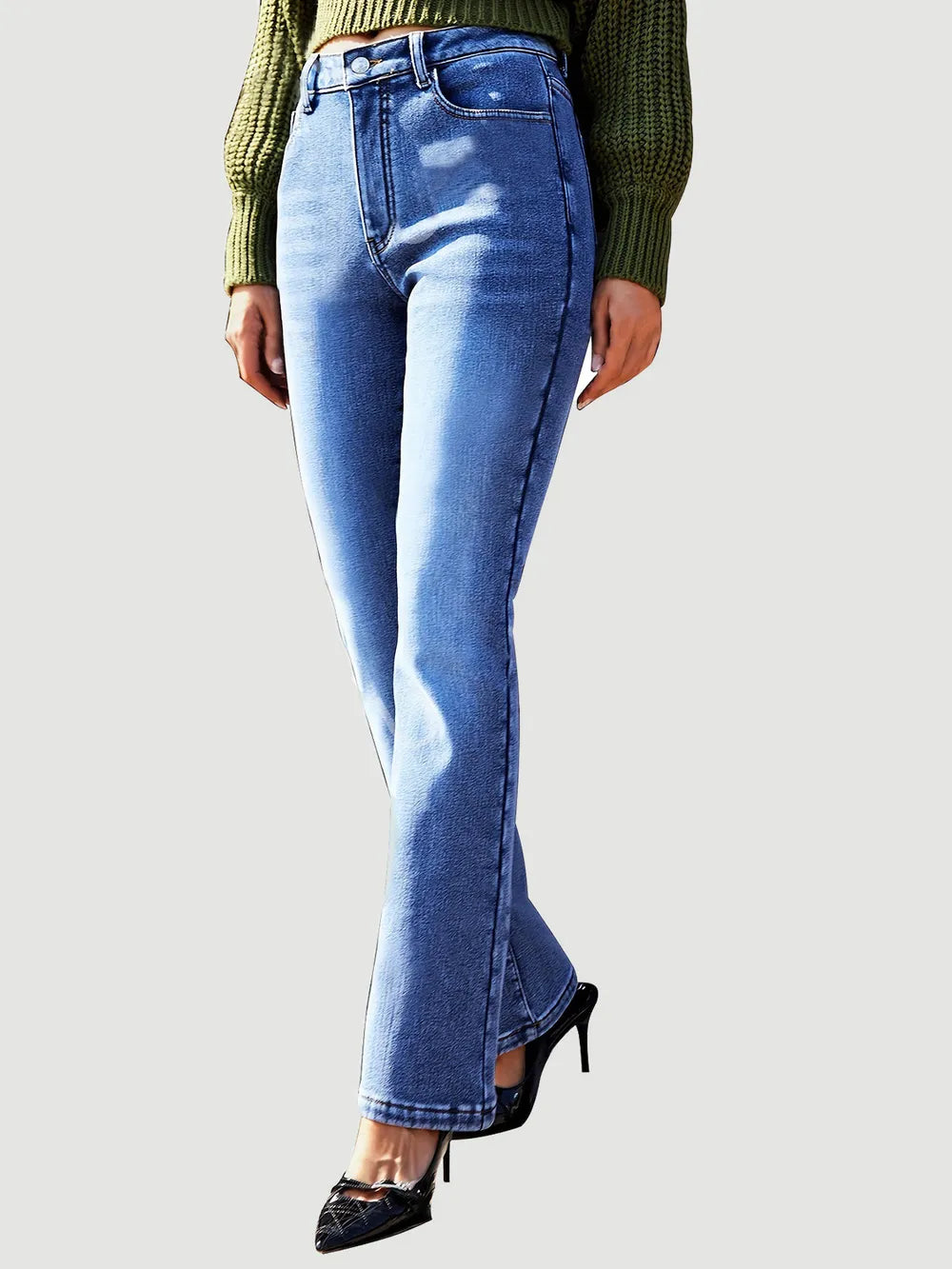 Blue jeans worn by a person on a plain background