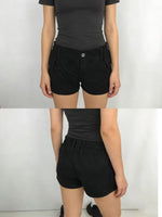 Black shorts worn by a person on a white background
