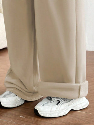 Beige pants with white sneakers on a wooden floor