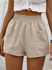 Beige shorts worn by a person with a white top against a light background