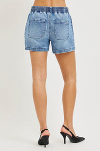 Denim shorts worn by a person on a white background
