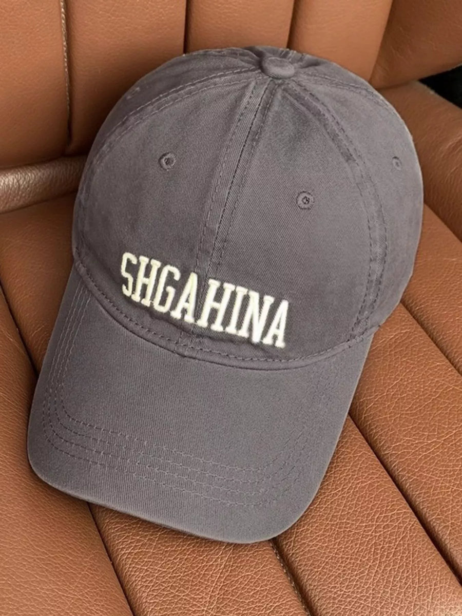 Gray cap with 'SHGAHINA' text on a brown leather surface