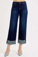 Dark blue jeans with floral cuffs on a white background