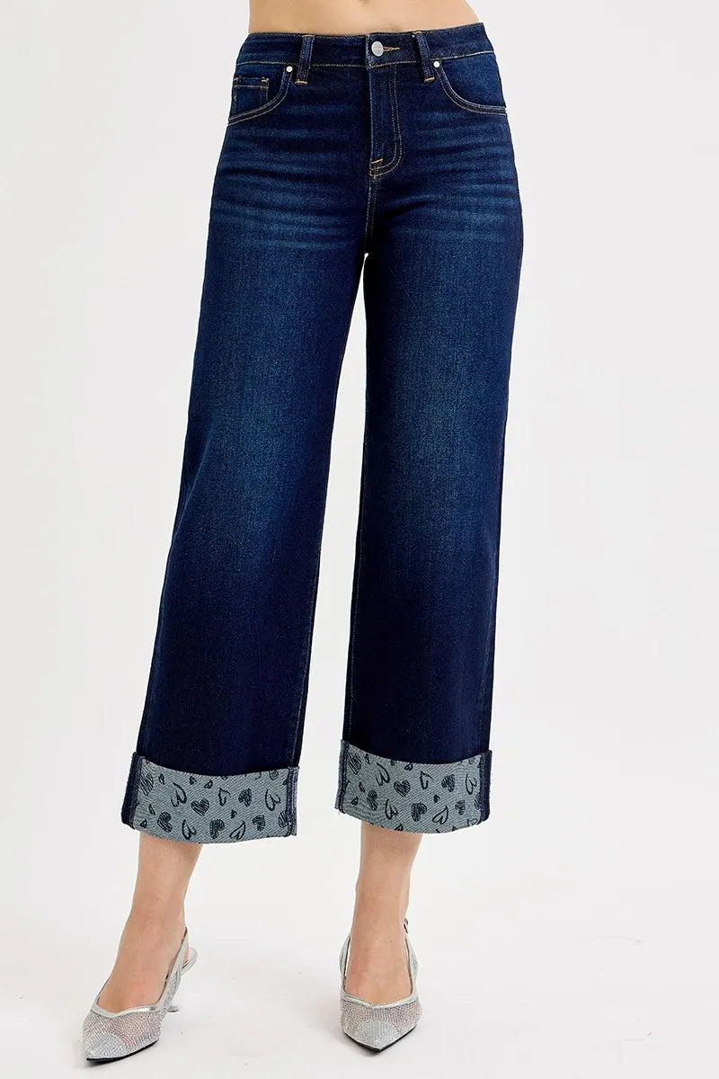 Dark blue jeans with floral cuffs on a white background