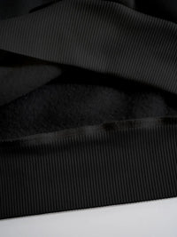 Close-up of black ribbed fabric on a white background
