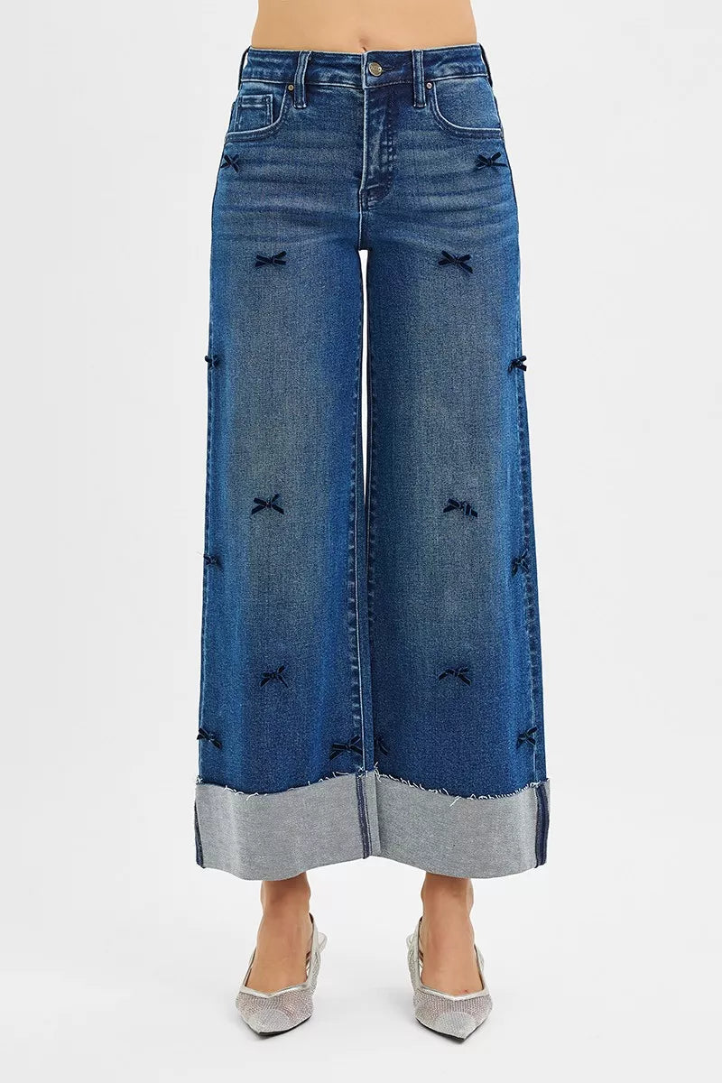 Blue denim wide-leg pants with decorative stitching on a white background