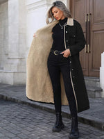 Woman wearing a black coat with beige lining on a city street.