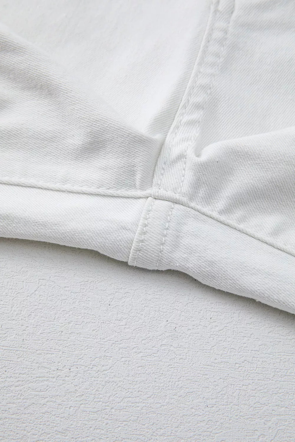 Close-up of white fabric with a focus on texture and stitching