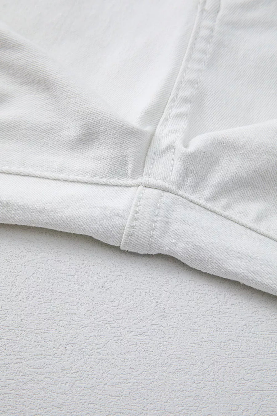 Close-up of white fabric with a focus on texture and stitching